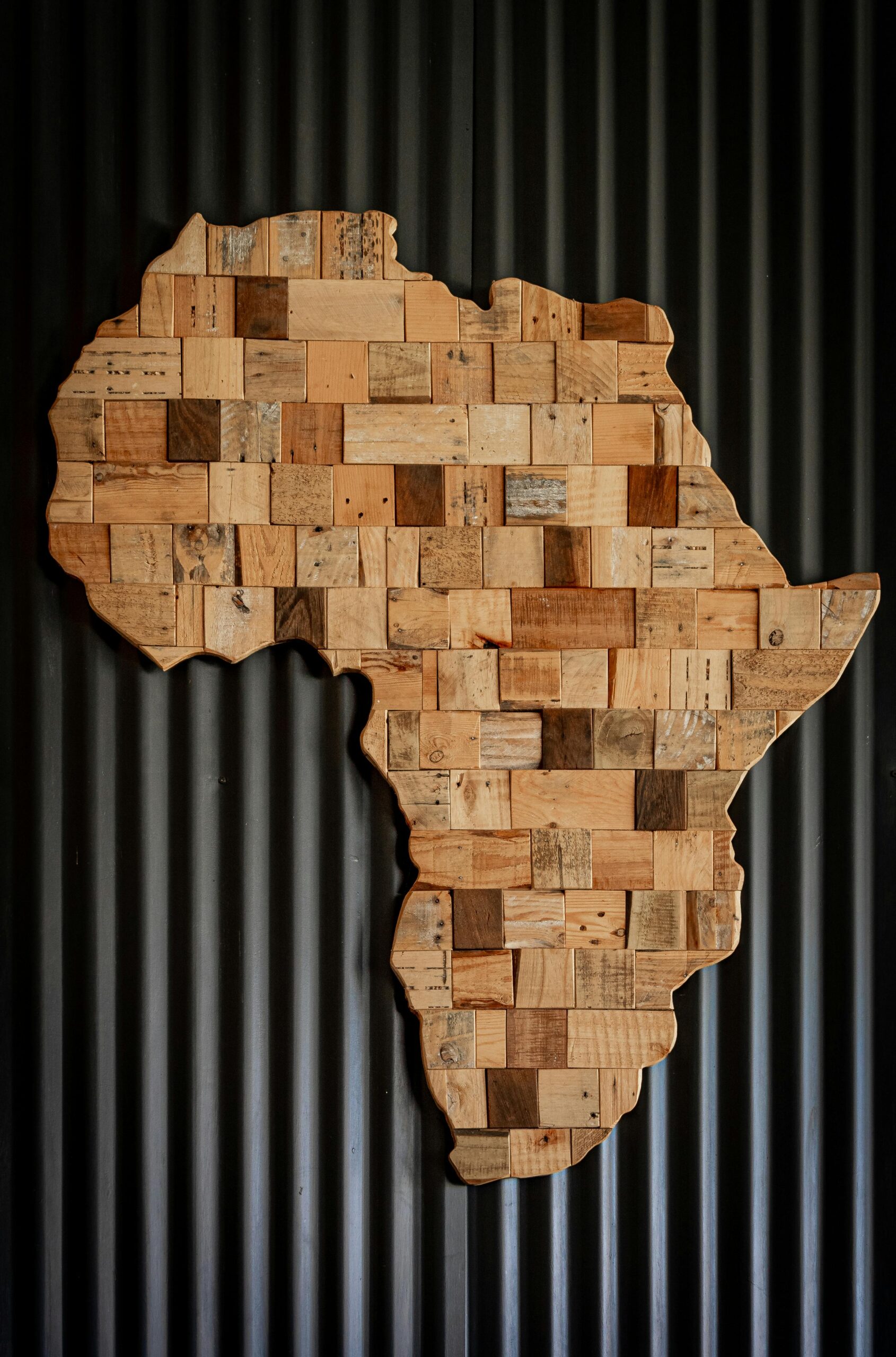 About us Artistic wooden map of Africa against dark corrugated background.