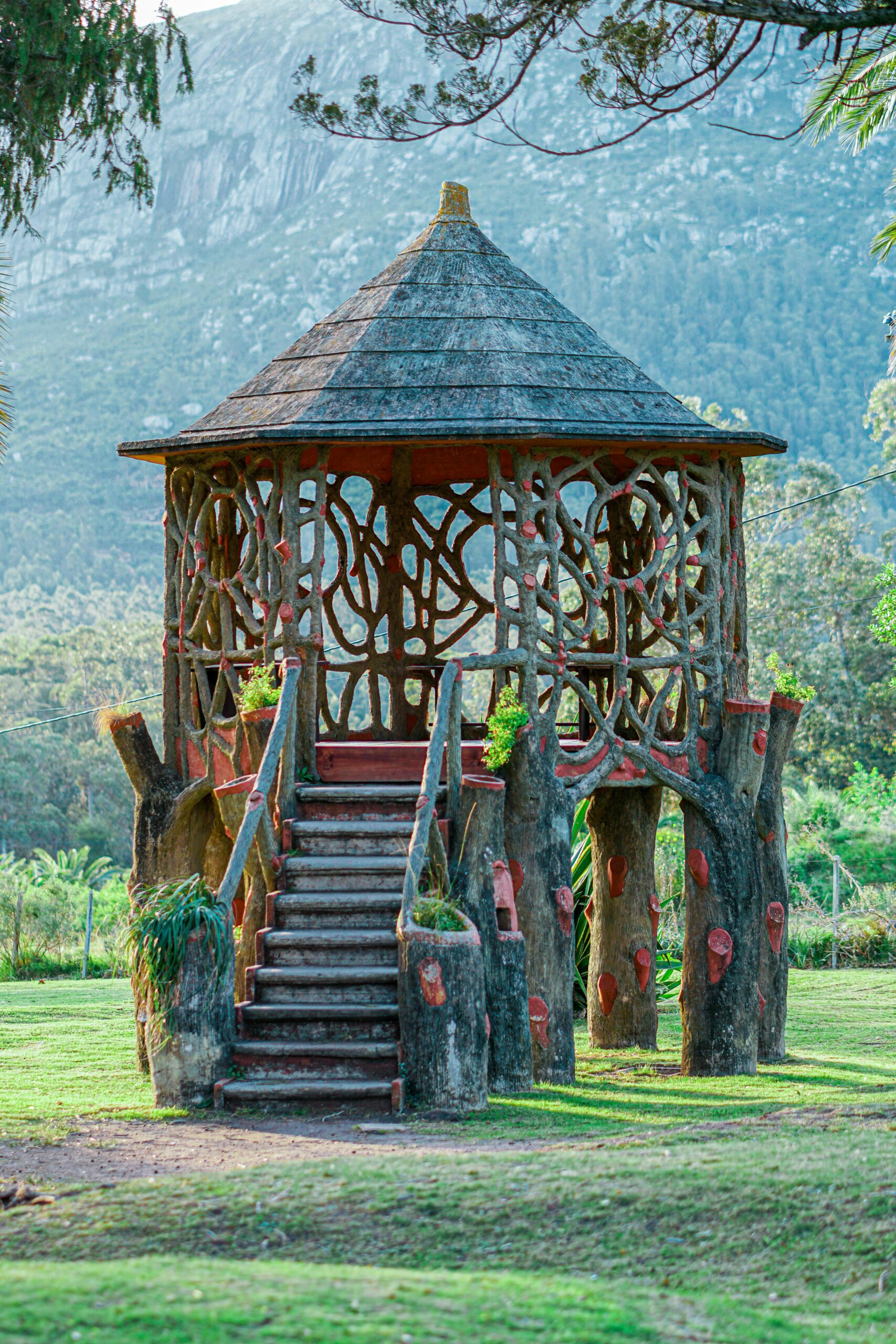 Rustic wooden gazebo in a lush park setting, surrounded by scenic mountains in Maldonado, Uruguay.