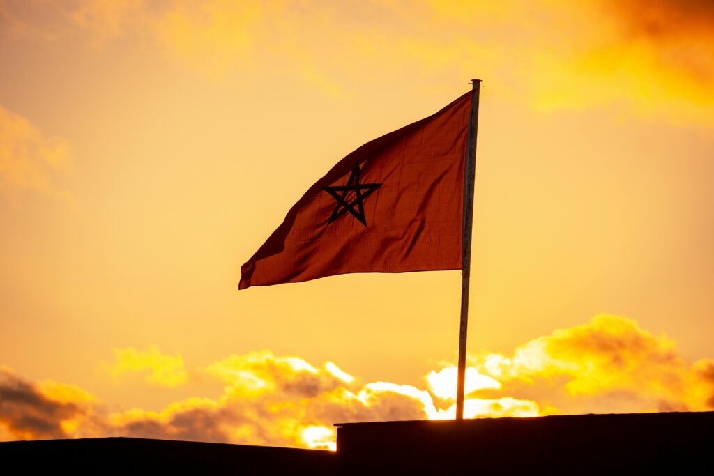 Morocco: AMMPS Launches Dedicated Email for Health Vigilance Activities (2026) Beautiful silhouette of Moroccan flag against vibrant sunset sky in Sidi Rahal, Morocco.
