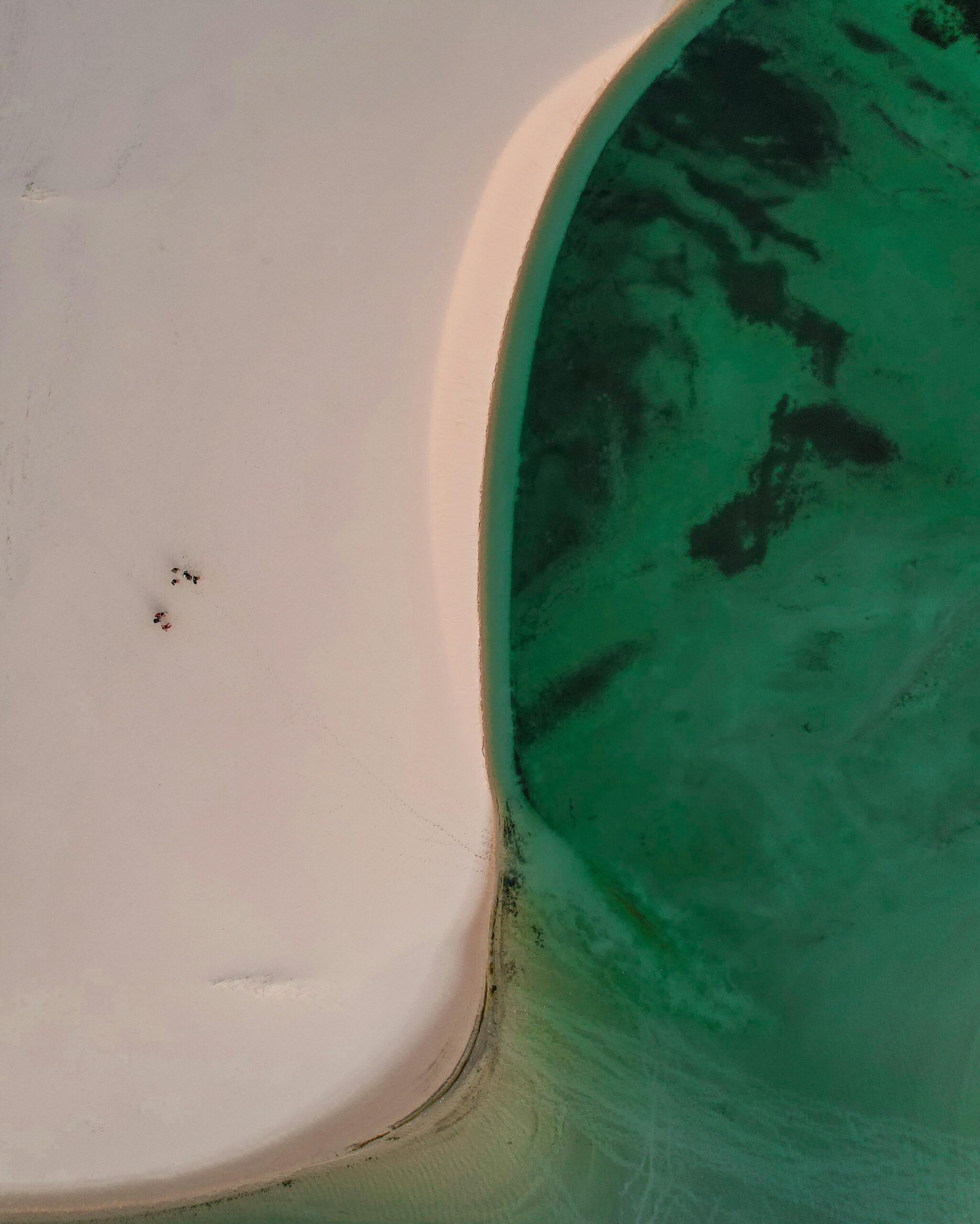Stunning aerial shot of the unique sand dunes blending with a vivid turquoise lagoon in Maranhão, Brazil.